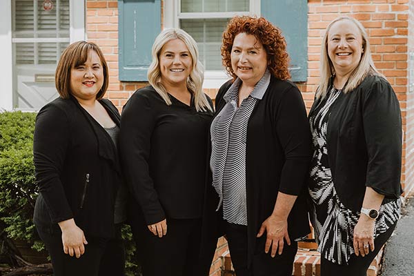 Image of all the administrative team members standing together in front of Cleary Dental office building.